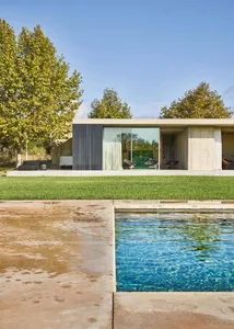 Modern minimalist residential architecture featuring clean lines and a large glass window.
