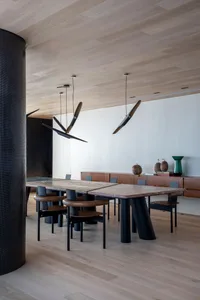 Modern dining room featuring wooden tables, metallic chairs, and leather accents.