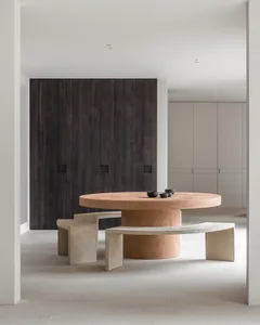 A minimalist interior space featuring a modern concrete table and benches.