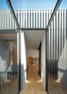 Modern architectural design featuring a glass doorway leading to an open space