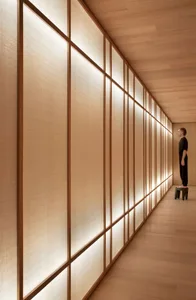 A minimalist interior space featuring modern wood paneled walls with soft lighting.