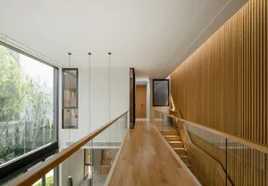 Modern residential hallway with wooden flooring and walls featuring a sleek design.