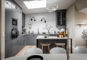Modern residential kitchen with concrete countertops, stainless steel appliances, and glass cabinets.