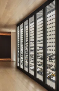 A modern wine cellar with glass doors filled with numerous bottles of wine.