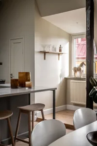 A minimalist kitchen with a concrete bar counter and wooden stools.