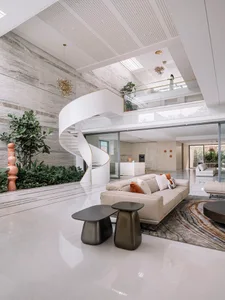 Modern living room with concrete, glass, and marble elements.