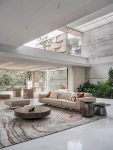 Modern minimalist living room with concrete walls, wood accents, and marble floor.