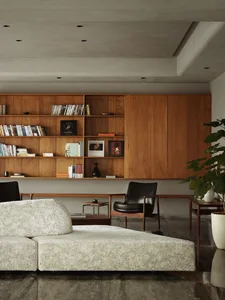 A modern living room with a white textured sofa, wooden shelves, and black armchair.