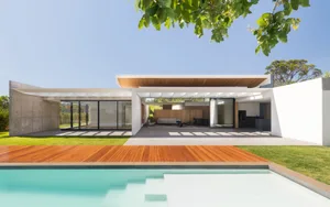 Modern residential exterior featuring concrete, glass, and wood materials.