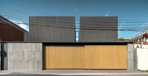 Modern residential facade featuring metal siding and wood panels.