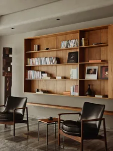 A modern living room featuring a wooden bookshelf filled with books and decorative items.