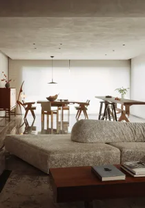 A modern living room featuring a large couch with textured fabric, wooden furniture, and a sleek, contemporary design.