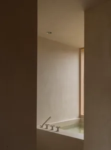 簡約浴室內有混凝土牆面，以及一扇可眺望戶外的窗戶。