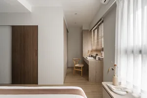 A minimalist bedroom featuring wooden furniture and materials, with soft lighting and a clean, uncluttered design.