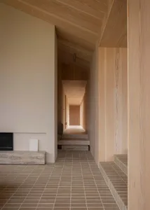 A minimalist interior design featuring wooden elements and a tiled floor.