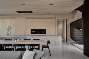 A modern kitchen with concrete cabinets and black accents.