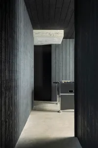 A modern game room with concrete floors, walls, and ceiling.
