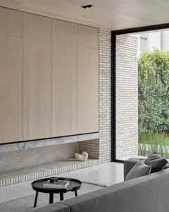 A modern living room featuring concrete, brick, and wood materials