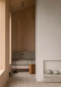 A minimalist living room with wooden accents and a cozy seating area.