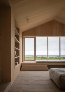 Minimalist residential interior with large windows showcasing ocean view