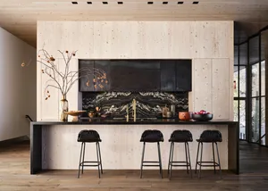 A modern residential kitchen with wood cabinets and black granite countertops.