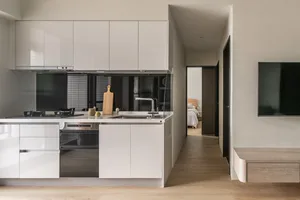Modern residential kitchen with minimalist design, featuring white cabinetry and minimalist decor.
