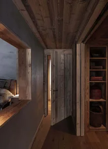 An image showing a hallway with wooden doors and walls, featuring industrial design elements.
