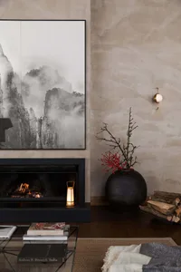 A cozy modern interior design featuring a living room with concrete walls, a fireplace, and a rustic vase with red berries, c