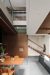 Modern residential interior with wooden furnishings, concrete flooring, and minimalist design features.
