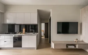 Modern residential kitchen with white lacquer cabinets, black countertops, and stainless steel appliances.
