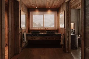 A rustic bathroom featuring wooden walls and marble sinks.
