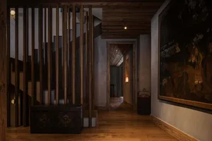 A corridor featuring wooden slats and antique decorative elements, with soft lighting and a rustic atmosphere.