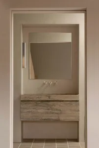 Modern minimalist bathroom featuring a concrete vanity, sink, and mirror.