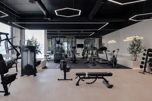 Modern, minimalist gym interior with metal, glass, and concrete materials.