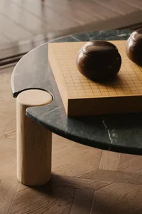 A modern marble table with a board game setup, featuring wooden pieces.