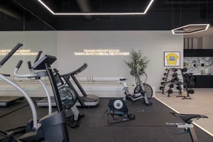 Modern gym with minimalist design featuring metal, glass, and wooden elements.