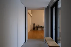 A minimalist living room with concrete walls and floor