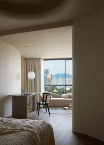 Modern minimalist bedroom featuring concrete walls, wooden furniture, and fabric finishes.