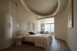 Modern minimalist bedroom with a white bed, fabric bedding, wood flooring, and glass window
