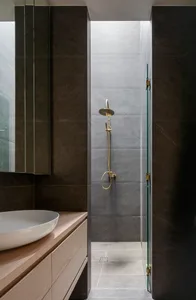 Modern minimalist black and gray bathroom shower space with ceramic tile walls.