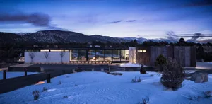 A striking modern concrete exterior with large windows at dusk.