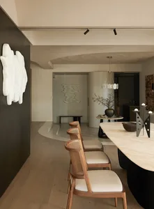 Modern dining room featuring marble table and wooden chairs.
