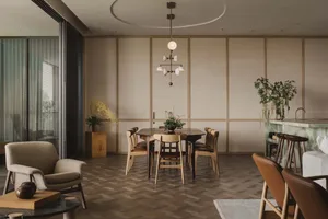 A modern dining room featuring wooden furniture and countertops, with a chandelier and plants.