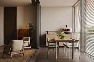 Modern minimalist kitchen with wood and metal elements and a plant on a table.