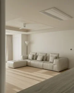 A modern living room with a beige leather sofa, matching ottoman, and light hardwood flooring.