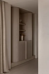A modern minimalist interior featuring wooden cabinets and shelves.