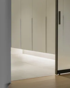 A minimalist bedroom featuring white wall panels and a concrete floor, creating a serene and contemporary atmosphere.