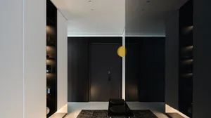 Modern minimalist entrance hall with metal accents, concrete flooring, and concrete lighting fixtures
