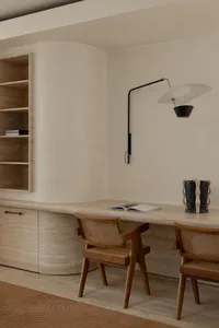Modern study desk area with wooden chairs and a marble top, featuring a minimalist design.