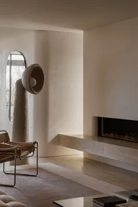 Modern living room featuring concrete fireplace and wooden floor and furniture, with a minimalist design aesthetic.